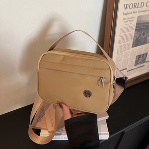 Khaki nylon crossbody bag with wide jacquard strap and minimalist zip design