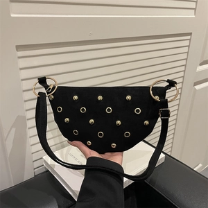 Black suede crescent shoulder bag with golden rivets and metal ring hardware