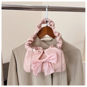 Détail du sac à main rose avec décoration de nœud et poignée nuage plissée