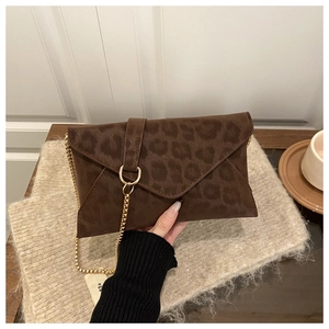 Close-up of leopard print envelope bag with gold metal chain and ring clasp detail