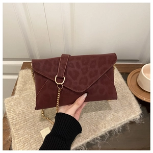 Detail of burgundy leopard print envelope bag with gold ring and metal chain strap