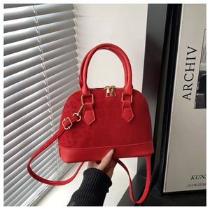 Détail du sac rouge avec gaufrage léopard et finitions métalliques dorées élégantes