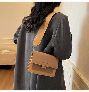 Detail of contrast color crossbody bag with wide fabric strap and metal swivel hook