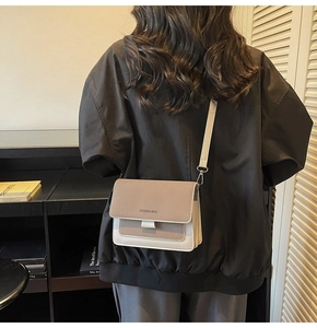 Rear view of a model wearing the contrast color crossbody bag with wide shoulder strap