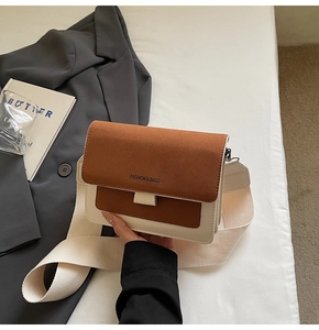 Detail of minimalist two-tone crossbody bag with wide strap and fashion lettering