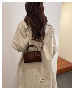 Detail view of dark brown leather mini bag with side knot and slim shoulder strap