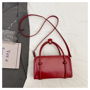 Detail of burgundy leather rectangular tote with Fashion embossing and slim shoulder strap