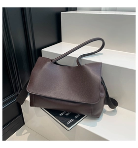 Macro shot of dark brown litchi pattern leather tote bag with minimalist rectangle design