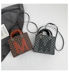 Detail of mini square tote bags in brown and black with M pattern and crossbody straps