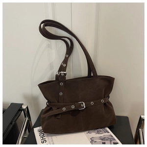 Detailed close-up of dark brown suede tote bag featuring retro buckle and metal eyelets