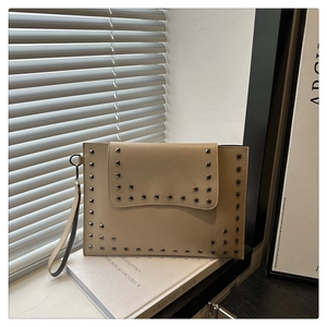 Detail of vintage envelope clutch bag featuring silver square rivets and wrist strap