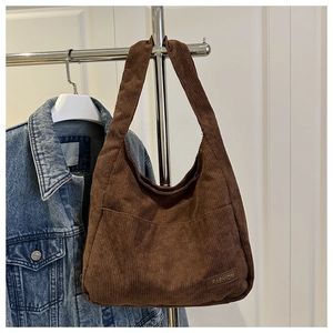Detail of coffee brown corduroy tote bag showing wide ribbed fabric and fashion leather patch