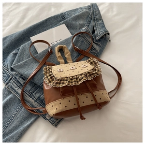 Detail of sweet floral embroidery and brown polka dots on a vintage drawstring backpack