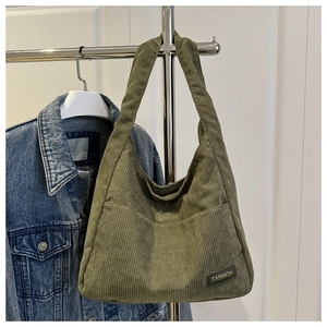 Close-up of avocado green corduroy tote bag showing striped texture and fashion label