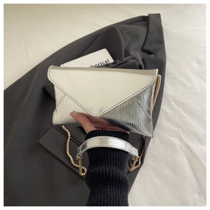 Detail showing the silver water ripple texture and golden chain on this envelope clutch bag