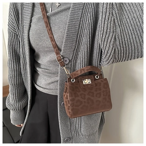 Détail du mini sac bandoulière vintage léopard avec fermoir rotatif en métal et texture suède