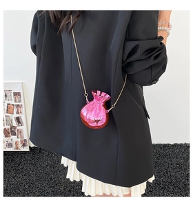 Detail of a pink metallic lucky bag crossbody bag with a slim golden chain strap
