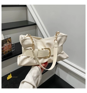Détail du sac en cuir plissé crème avec boucle dorée et bandoulière en chaîne