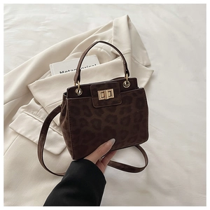Detail of leopard print bucket bag showing suede texture and golden metal twist lock