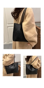 Detail view of large black tote bag with vintage pleated texture and long shoulder strap