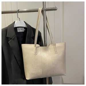 Detail of minimalist cream tote bag with vintage texture on a metal display stand