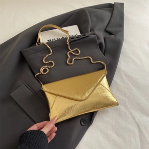 Elegant gold envelope crossbody bag with vertical texture and sleek gold chain strap
