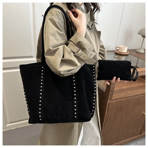 Détail du sac cabas en daim noir avec rivets argentés et pochette assortie
