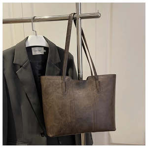 Detail view of large brown retro tote bag with vintage texture and long handles