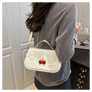 Détail du sac bandoulière blanc crème en cuir PU avec accessoire cerise 3D et rabat