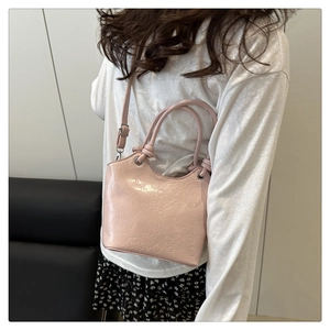 Detail of pink crossbody bucket bag featuring 3D embossed cartoon icons and textures