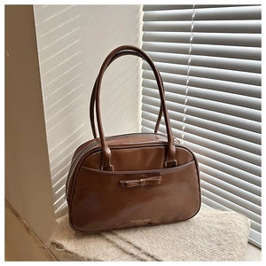 Détail du sac à bandoulière marron brillant avec nœud papillon et logo Fashion & Bags