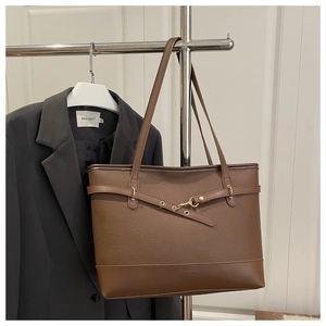 Detail of dark brown lychee grain leather tote bag with elegant gold hardware buckles