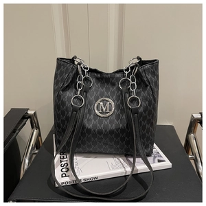 Détail du sac cabas noir avec motif jacquard en M et emblème métallique argenté