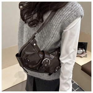 Detail of dark brown underarm bag featuring silver buckle and Y2K aesthetic design