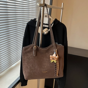 Brown faux suede tote bag with white contrast stitching and a small teddy bear charm