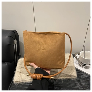 Detail of suede crossbody bag in brown featuring fashion and classic embossed text