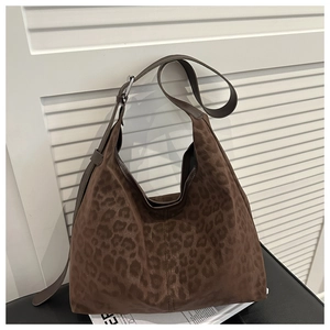 Macro shot of the leopard print faux suede fabric and silver buckle on the shoulder bag