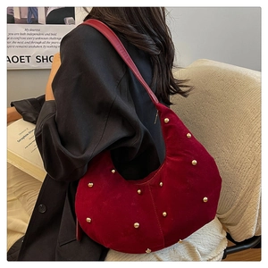 Close-up of wine red hobo bag with gold rivet studs and textured suede material