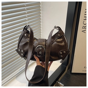 Detail of dark brown faux leather motorcycle bag with silver rivets and buckle