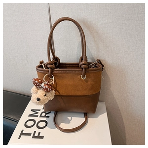 Detail der Vintage-Patchwork-Beuteltasche mit Wildlederoptik und Plüschbär-Anhänger