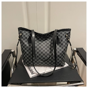Detail of large tote bag showing M-letter jacquard pattern and premium gold hardware