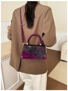 Detail of color-block crossbody bag featuring snakeskin texture and purple patent leather