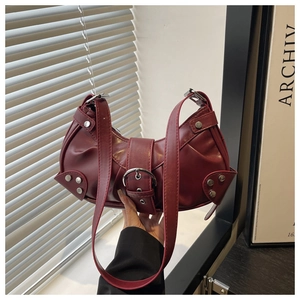 Close-up of vintage dark red crescent bag with metal buckle and rivet details