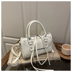 Detail of off-white rivet boston bag with long tassel zippers on soft knit background