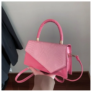 Close-up of pink lacquer finish and snakeskin pattern detail on a stylish handbag