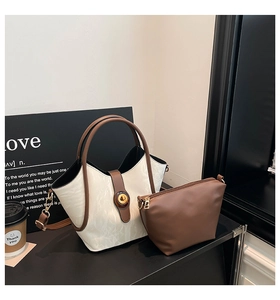 Close-up of contrast bucket bag with mini zipper pouch and vintage metal turn-lock