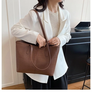 Detail of brown crocodile pattern tote bag with large capacity and slim shoulder straps