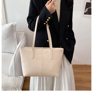 Close-up of creamy white crocodile pattern tote bag showing high-quality leather texture