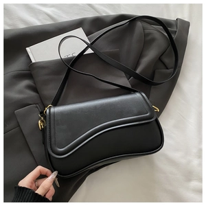 Detail of black faux leather crossbody bag with wave stitching and gold metal buckle