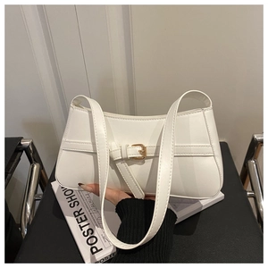 Close-up of a white baguette shoulder bag featuring minimalist leather strap and gold buckle